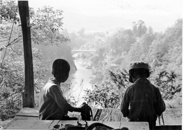 ふたりの少年が龍角峯（のりゅうかくほう）の展望所に座り姑射橋（こやきょう）を眺めている　昭和11年頃の白黒写真　　