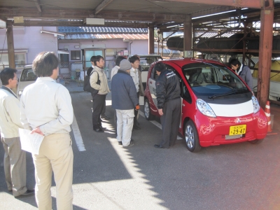 電気自動車に集う人々の画像